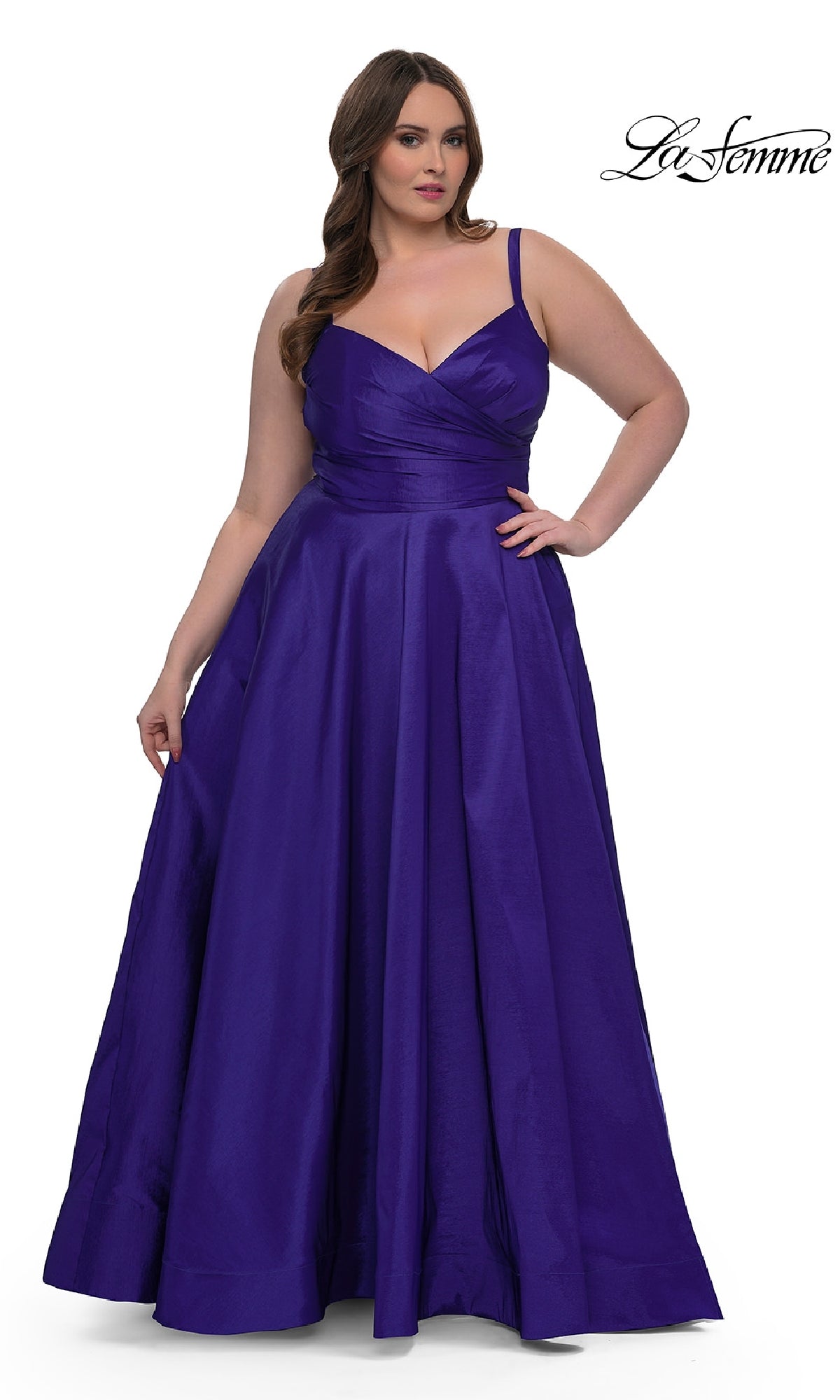 A woman models the La Femme 33075, a long plus-size prom dress with a fitted bodice and elegant A-line skirt in deep purple, against a white background. The